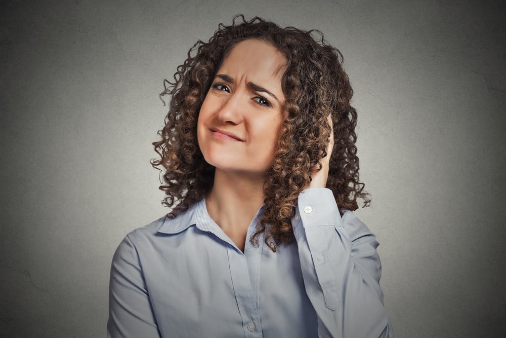 woman with hand on head making an unsure gesture 