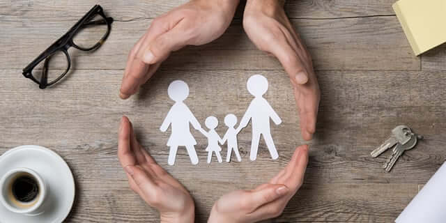hands circling a paper cut out of two adults holding two childrens hands